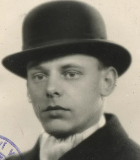 Vintage black-and-white passport photo of a man  wearing a bowler hat.
