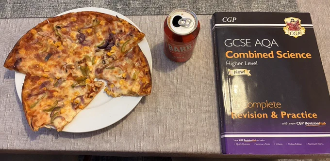 A plate of pizza, a can of Barr cola, and a CGP GCSE AQA Combined Science textbook