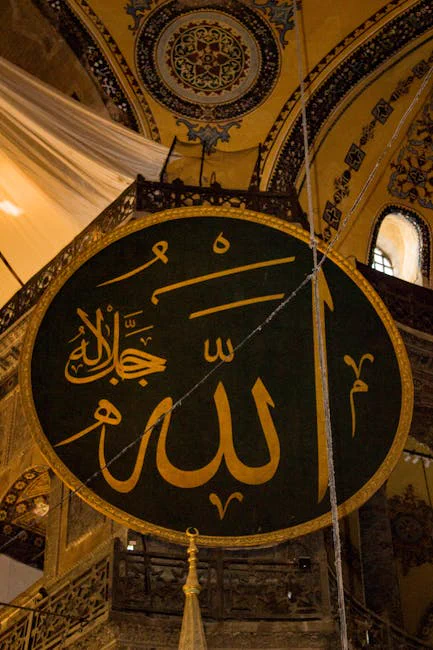 Beautiful Arabic calligraphy depicting 'Allah' inside a historic mosque with rich decor.