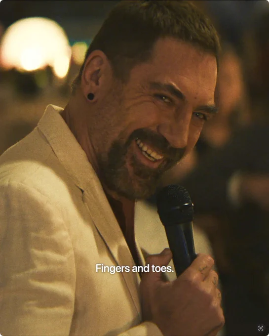 From Cape Fear. Javier Bardem as Max Cady smiles in a close-up while holding a microphone. “Fingers and toes” is written in white text at the bottom of the image.