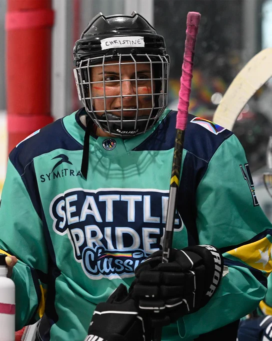 a photo of a skater in a green Seattle Pride Classic jersey smiling in the direction of the camera.