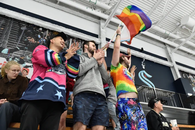a photo of fans cheering in rainbow attire at the Seattle Pride Classic.