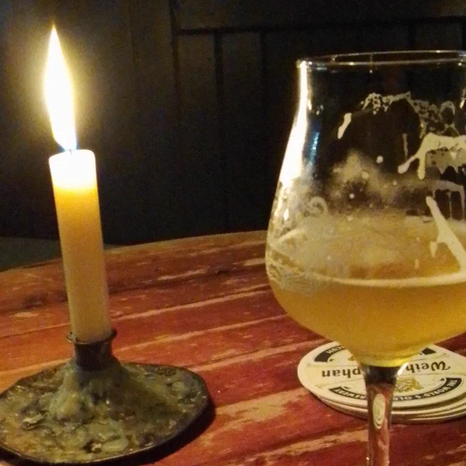 A candle and a glass of beer.