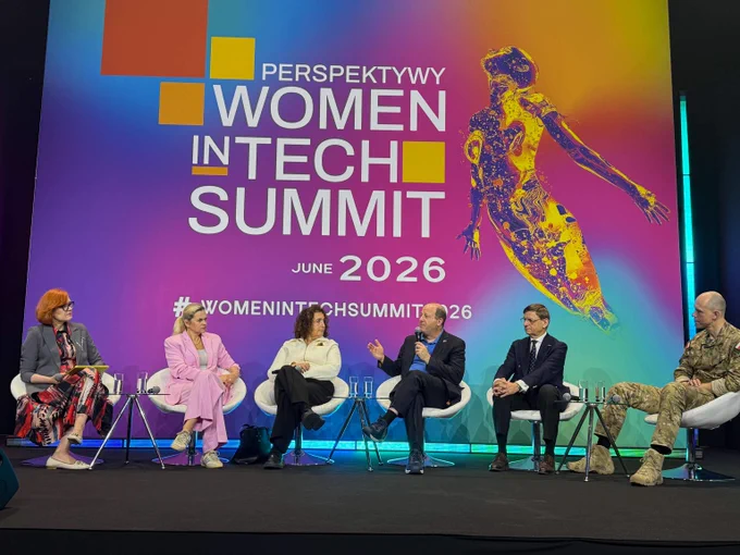 Panel of six diverse professionals seated on stage at the Women in Tech Summit 2026 discussing technology and innovation.