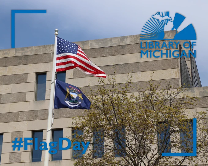 United States and Michigan flags outside the Library of Michigan.