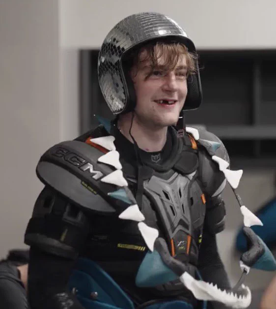Luca Cagnoni in the Sharks dressing room wearing the shark teeth over his chest pads and a discoball hat