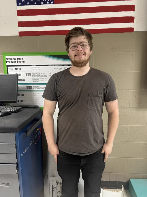 student standing in front of an amercican flag
