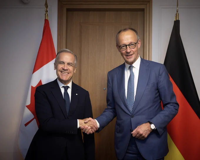 Photo of Prime Minister Carney shaking hands with Chancellor Friedrich Merz at the G7 Summit in Évian, France.