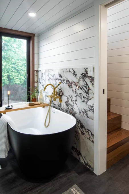 Black soaking tub against marble in the Cascade Max bathroom
