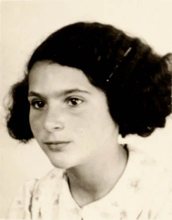 Black-and-white portrait of young girl with a thoughtful expression, wearing a light-patterned dress. Her hair is styled in curls framing her face.
