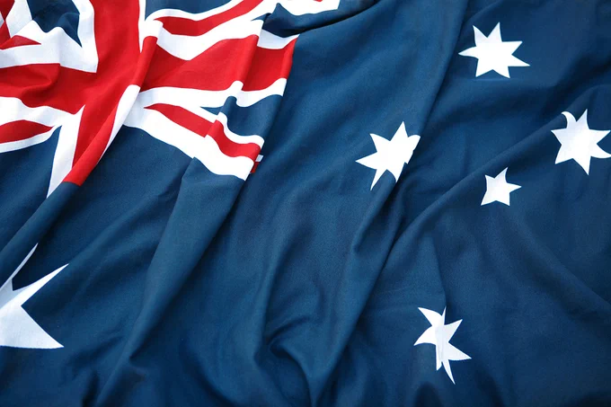 Close-up of the Australian flag showing the Union Jack and white stars on a blue field with fabric folds.