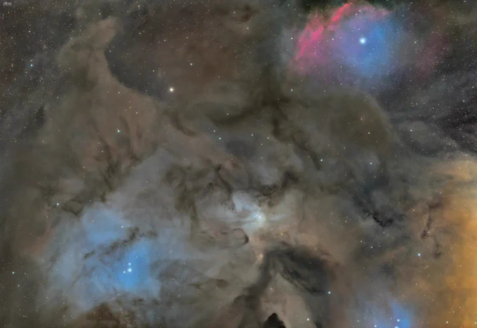 IC 4603 is a reflection nebula in the great Ophiuchus molecular cloud — one of the nearest stellar nurseries to our own solar system, a vast complex of gas and dust stretching across hundreds of light years of the southern sky. The blue luminosity is not emission but reflection — nearby stars scattering their light through the surrounding dust, the way moonlight catches in fog. The dark forms rising through it are the silhouettes of denser cloud structures, cold molecular material opaque enough to block everything behind them. They do not glow. They stand.

At the centre of the frame, in a small clearing where the mist thins and the light gathers, two figures appear to meet. Whether this is arranged or accidental, welcomed or dreaded, the forest does not say. It folds around them — neither threatening nor protective, or perhaps both simultaneously. The amber warmth at the edges could be a distant hearth, a fire kept burning by someone waiting. 