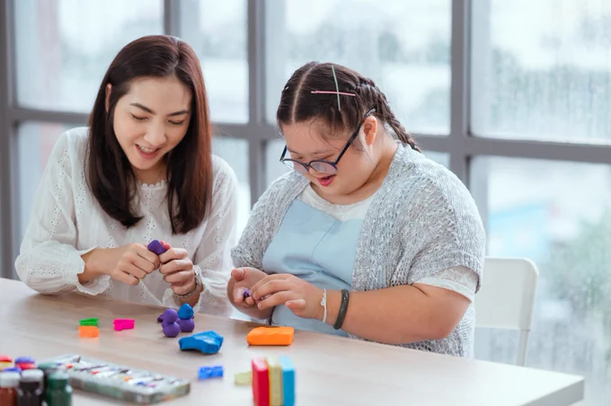 Adult playing with a young person with learning disabilities
